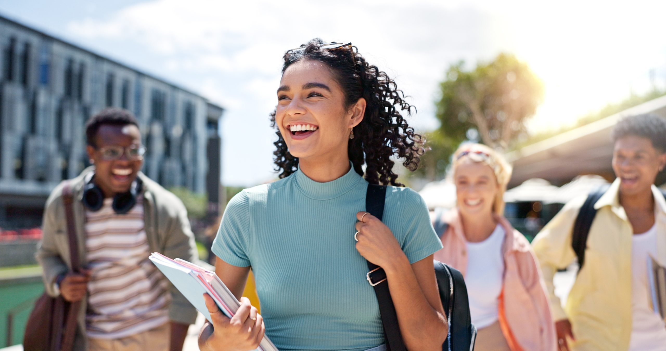 girl smiling and walking with books in her hand